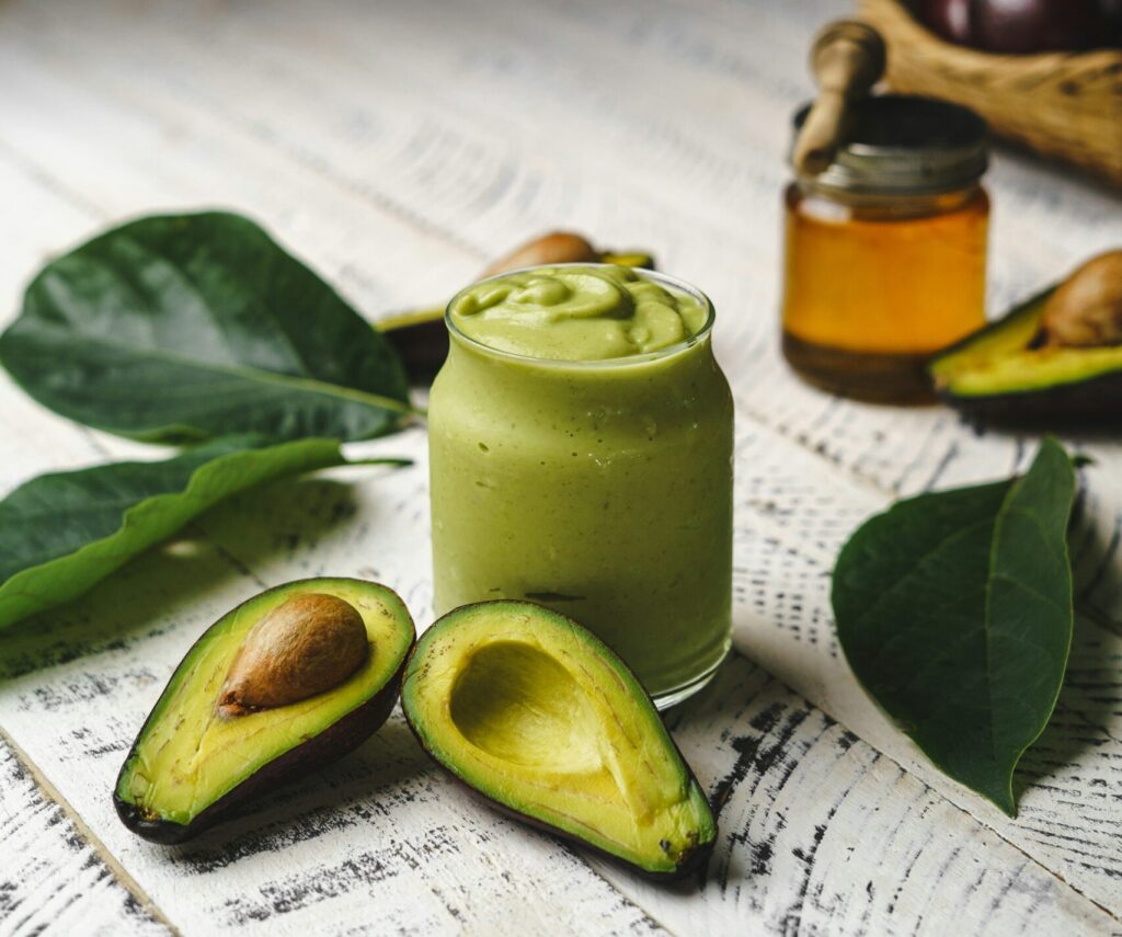 Green smoothie with cut open avocado halves