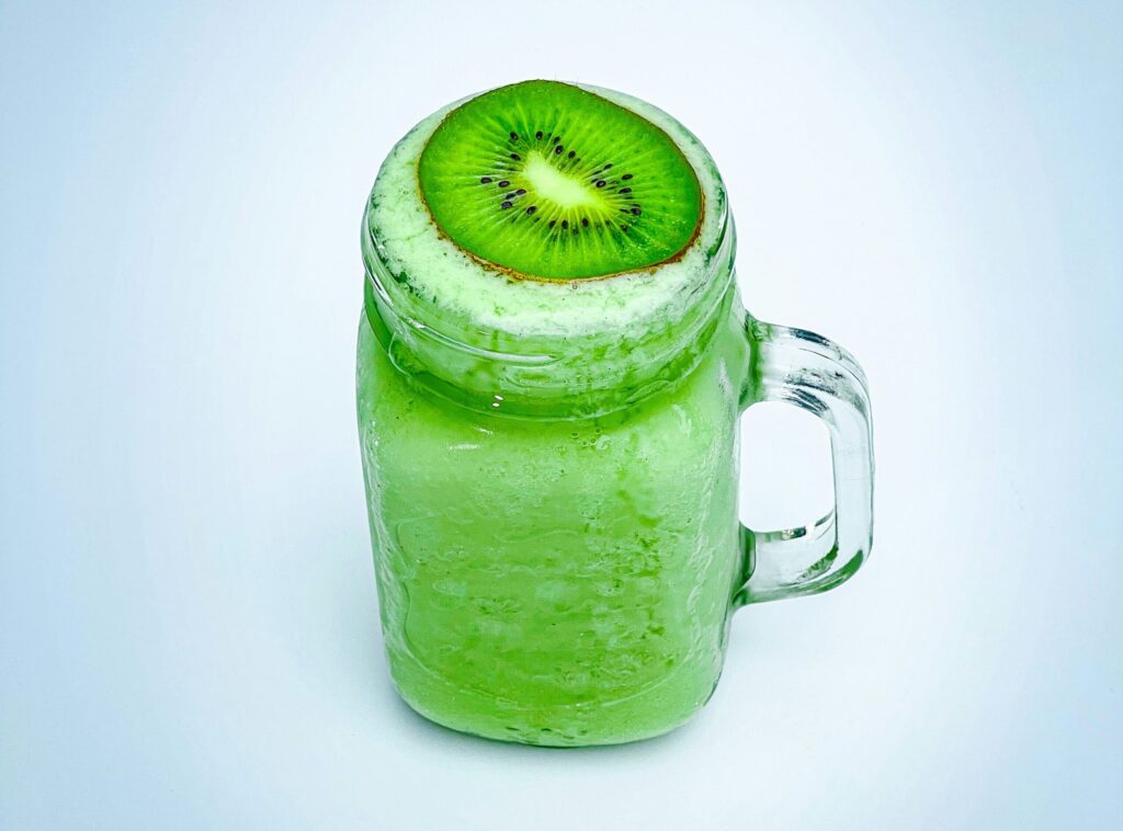 Healthy green smoothie topped with a kiwi slice