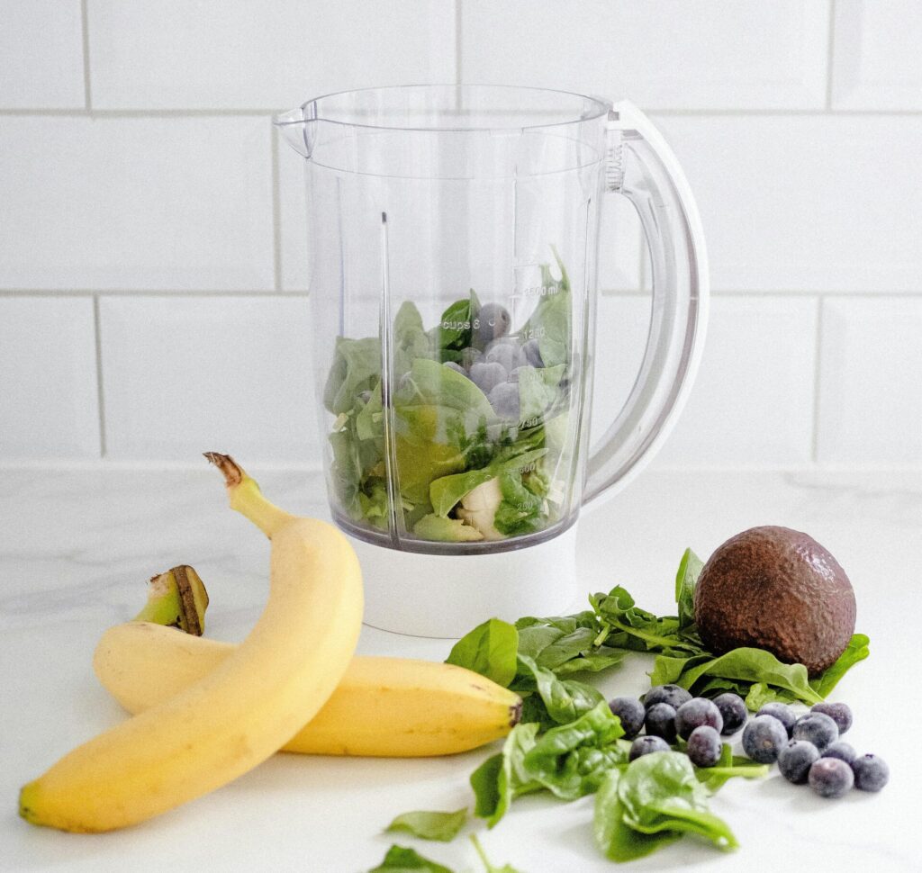 Smoothie jug with bananas, spinach and blueberries