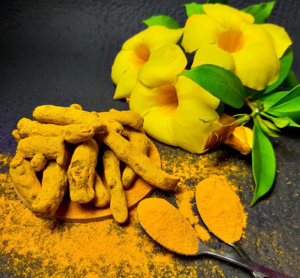 Whole and powdered turmeric with yellow flowers