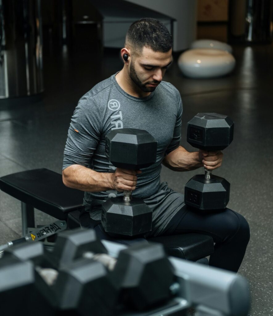 a man in the gym holding dumbbells